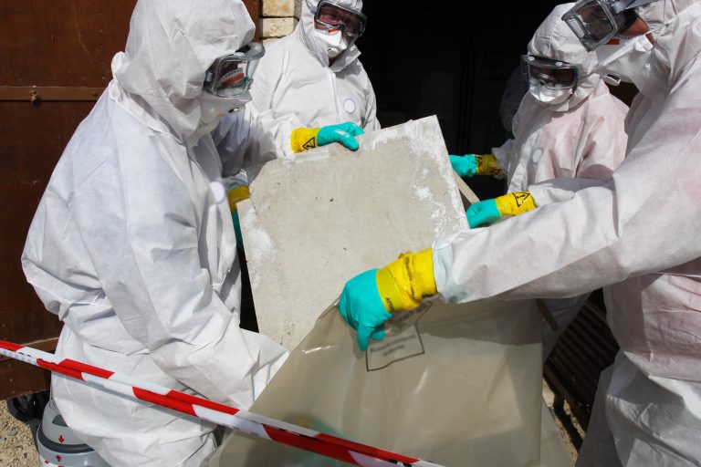 Protected with PPE construction employees safely removing asbestos
